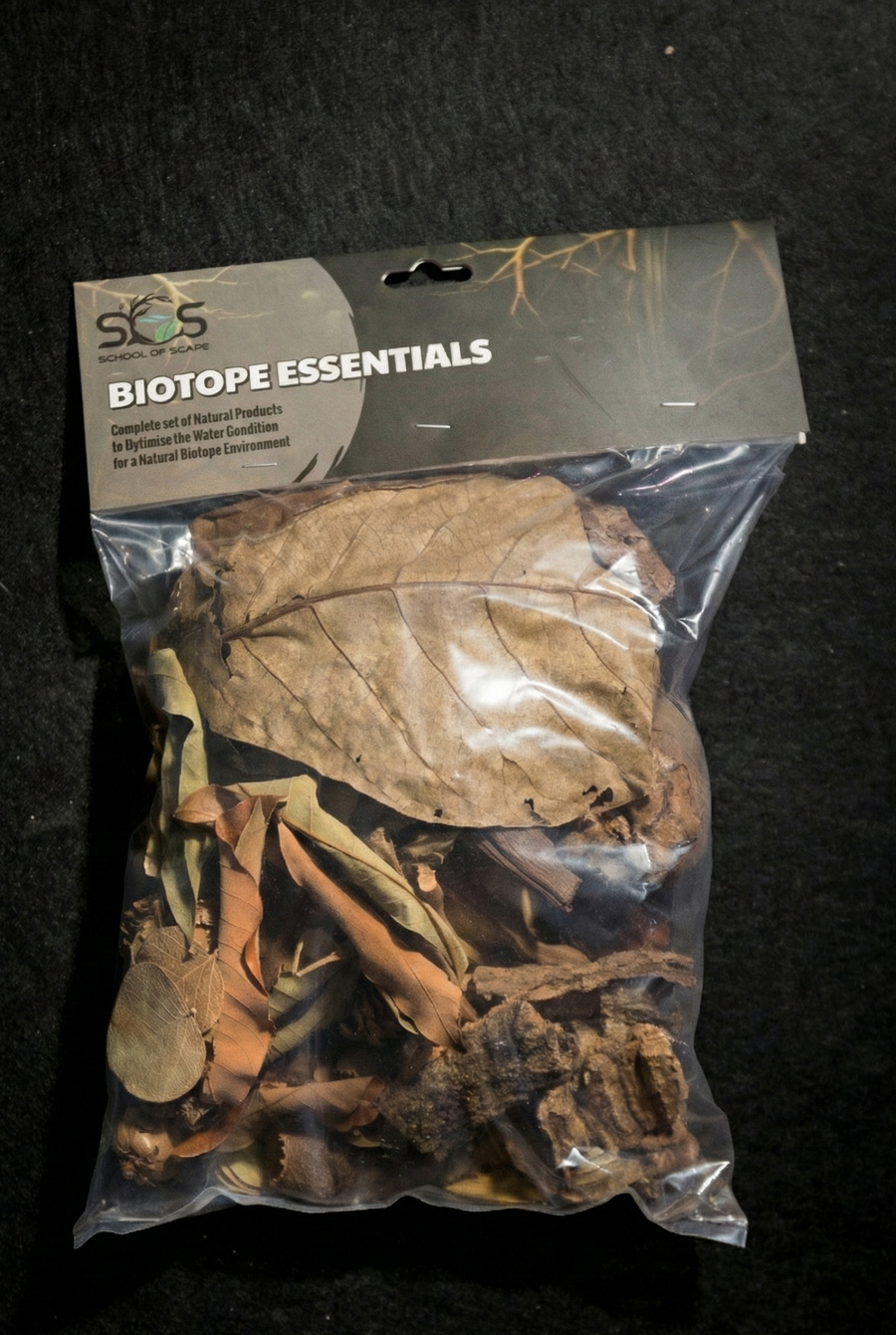 Packaged biotope essentials with dried leaves on a black background